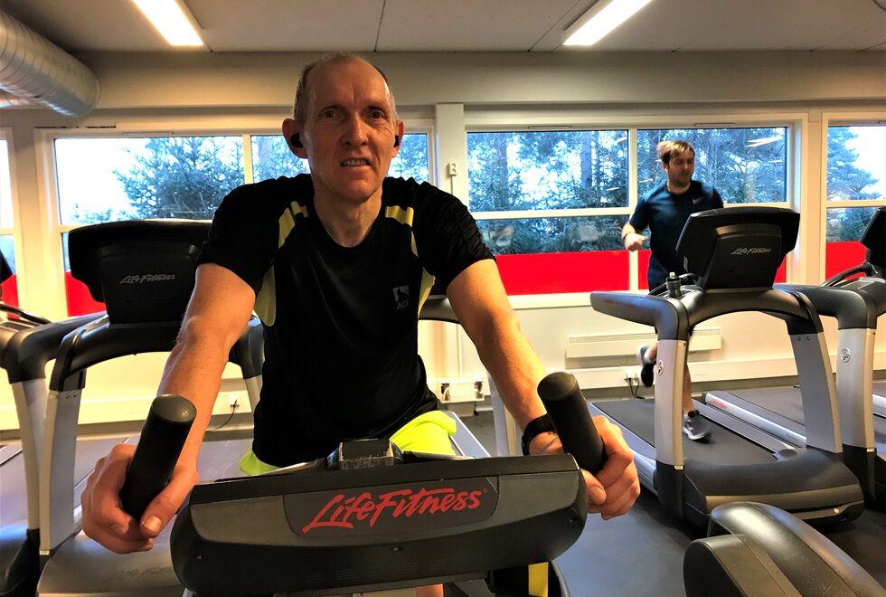 Arild Hansen har en sykkeløkt på ergometersykkelen hver dag. Det blir det kilometer av. (Foto: Marianne Røhme)